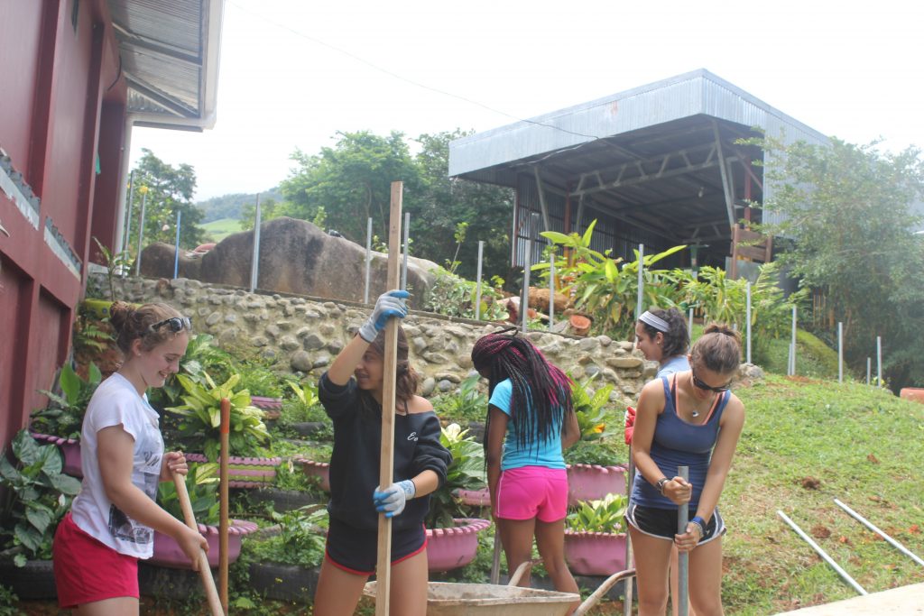 The girls digging holes for poles
